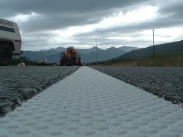 This photo shows a close-up view of marking tape in a recessed pavement groove.