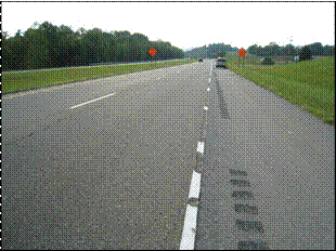 This photo shows a two-lane test deck section in Tusculum, TN, where parts of the pavement marking tape have been scraped away by snowplowing activities