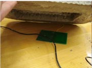 This photo shows a sensor placed under a concrete specimen.