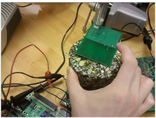 This photo depicts the test setup for an asphalt concrete (AC) specimen. It shows the concrete specimen with the receiver placed on top.