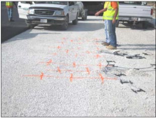 This photo shows orange markings on the ground, indicating the proposed locations of the gauges.