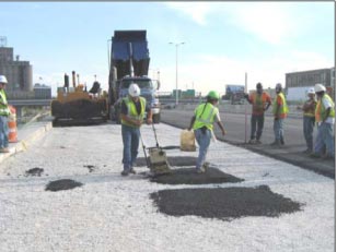 This photo shows construction workers compacting unscreened asphalt over the gauge arrays with a