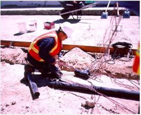This photo shows a construction worker and the instrument wiring and piping laid in aggregate base.