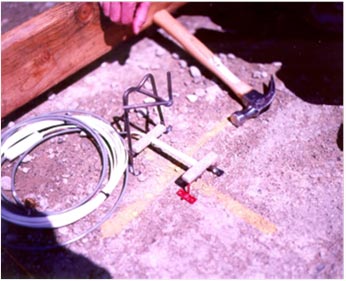 This photo shows steel frames for mounting strain gauges in concrete pavement. They are sitting on a yellow