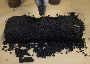 This photo shows the black asphalt mix in a pile on the floor.