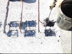 This photo shows the sensors placed in the holes described in the previous photo, with a worker covering them