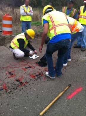 This photo shows construction workers placing asphalt over the sensors.