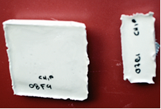 This photo shows two encapsulated radio frequency identification tags. The encapsulated tags are about the same length. The tag on the right (monopole) is about one-fourth of the width of the tag on the left (single patch). There are notations on both tags for identification, but they are not legible in the photo.