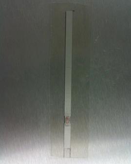 This photo shows the dipole antenna that is made of silver conductive paint. The antenna is in the vertical position. From the bottom, the silver paint measures 0.8 inches, which then connects to the radio frequency identification chip and antenna. The silver paint continues upward from this location for 3.2 inches.