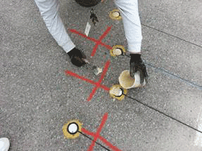Figure 34. Photo. Final grouting of sensors. This photo shows a worker grouting the embedded sensors in the pavement.