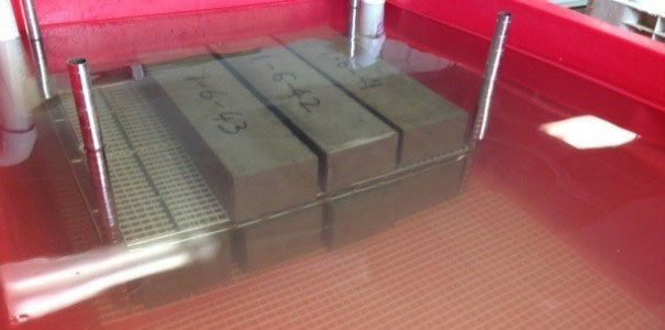 FIGURE 5. Beams placed on grid panels. This closeup shows beams on grid panels submerged in a lime water curing tank. FIGURE 5. Beams placed on grid panels. This closeup shows beams on grid panels submerged in a lime water curing tank.