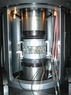 Figure 4. Photo. Superpave Shear Tester. This is a photo of the Superpave Shear Tester chamber shown in figure 3. In addition, it shows thermocouples attached to the asphalt mixture specimen, which record the temperature during testing.