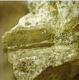 Figure 3. Photo. Photograph of the lithium-bearing mineral spodumene. It shows a close-up view of a jagged, tan-colored rock.