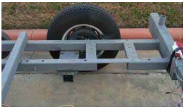 Photograph shows a torsion axle and mounting plate.