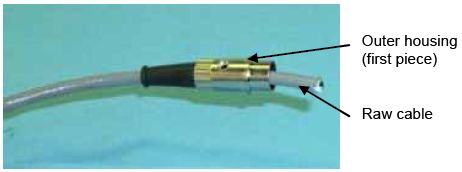 Photograph shows a raw cable and DIN plug housing. Arrows indicate the locations of the outer housing open parenthesis first piece close parenthesis and raw cable.