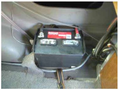 Photograph shows an electronics battery located inside the F W D vehicle securely mounted to the vehicle floorboard.