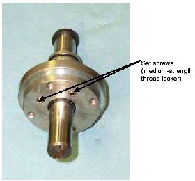 Photograph shows an assembled catch flange and release piston. The view of the component is from the top, and arrows indicate the locations of the set screws open parenthesis use medium-strength thread locker close parenthesis.