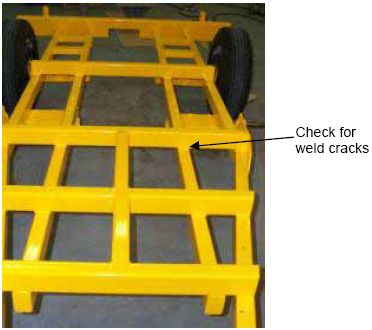 Photograph shows the rear view of a newly powder-coated trailer. An arrow indicates the location on the trailer to check welds for cracks.