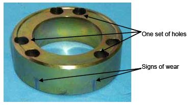 Photograph shows an inner ring. Arrows indicate the locations of one of two sets of three holes, and two areas showing signs of wear.