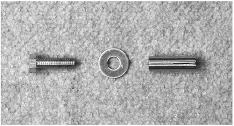 Figure 107. Photo. Concrete anchor. This photo shows three elements from left to right: a hex head cap screw, a washer, and a concrete anchor.