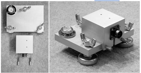 Figure 116. Photo. Accelerometer box attached to calibration platter. This photo shows two views of the attachment of the accelerometer box to its calibration platter. This left panel is taken from above showing how the platter, accelerometer box, and screws line up with each other. The right panel shows a top view of an aluminum accelerometer box attached to an aluminum calibration platter. The accelerometer box is attached to the front of the platter by two knurled thumb screws. Three wing nuts attached to feet are used to level the platter. A bubble level on the back left corner of the platter is used to confirm that the platter is level.