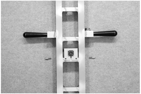 Figure 120. Photo. KUAB geophone adapter equipment. This photo shows KUAB geophone adapter equipment. On the left is the clamp that hooks to the KUAB geophone. On the right is a magnetic cup with a bolt that screws into a black knurled knob that is painted gold around the knurled end.