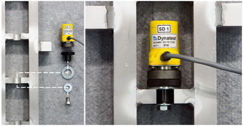 Figure 33. Photo. Attachment of a Dynatest<sup>®</sup> geophone in the stand. This photo shows the attachment of a Dynatest ® geophone in the calibration stand and a close-up of an attached Dynatest ® sensor. The left panel shows the six components in an unassembled layout. The components are the Dynatest ® geophone, which is a yellow plastic cylinder with a wire out the front, a black knurled knob, a large upper washer, a small lower washer, an attaching bolt, and the front side of the geophone stand with a notched shelf for placing the geophone. The right panel shows the Dynatest ® geophone magnetically attached to a knurled knob, and the knob is bolted in place in the stand.