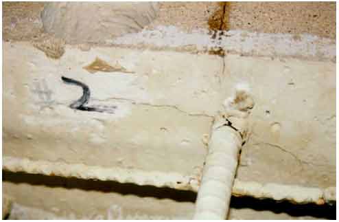 Figure 5. Photo. Termination of the top crack and other cracks on the front side of slab 2 in August 1994. This photograph shows the termination point of the surface crack and other cracks formed along a top mat rebar of slab 2.