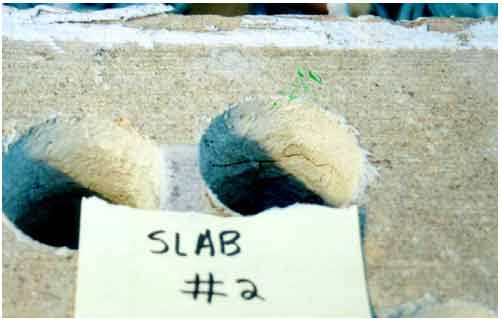 Figure 7. Photo. Cracking and rust staining at the level of reinforcing steel in core holes of slab 2. This photograph shows cracks on the insides of the core holes of slab 2 that also exhibited rust staining.