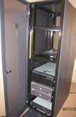 Tall computer cabinet with opened front panel revealing several “pizza box” server computers installed in stacked fashion inside.