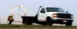 Figure 4. Photo. Class 8 truck pulling a trailer. This photo illustrates a commercial flatbed truck, similar in size to the Class 3 vehicle in figure 3, pulling a single axle trailer.