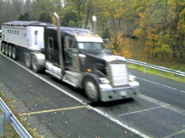 Figure 33. Photographs. Seven-axle Class 10 truck at Maryland site. This photo shows a seven-axle Class 10 truck observed at the Maryland site, consisting of a three axle tractor pulling a quad axle trailer.