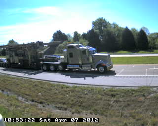 Figure 34. Photo. Seven-axle Class 10 truck in Tennessee. This photo shows a seven-axle Class 10 truck consisting of a large tractor pulling a low-boy trailer with heavy equipment on it.