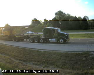 Figure 35. Photo. Ten-axle Class 13 truck in Tennessee. This photo shows a 10-axle Class 13 truck consisting of a 4-axle tractor pulling a low-boy trailer on an articulated support.