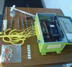 Figure C.4. Photo. Automated Temperature Datalogger set up on pavement with solar panel and cables attached to probes.