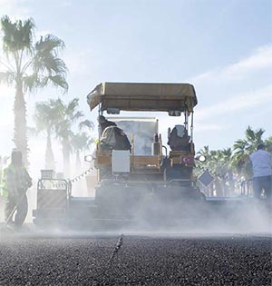 Photo. Asphalt paving machine at work. Credit: © muratart/Shutterstock.com.