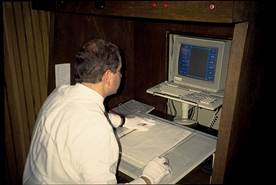 Figure 6.26. Photo. Worker with table and computer monitor.