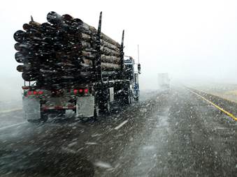 Photo. Highway with two trucks traveling in snowy weather. Credit: © Lane V. Erickson/Shutterstock.com.