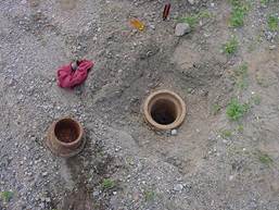 Figure 7.2. Photo. Piezometer well and cap sunk in pavement.