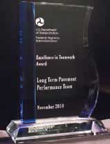 Photo. Glass award with USDOT/FHWA logo, stating 'Excellence in Teamwork Award, Long-Term Pavement Performance Team, November 2010.'