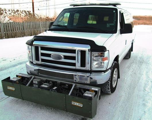 This photo shows a survey unit attached to the front of a vehicle. The sensor bar, mounted on the front of the vehicle’s bumper, is shown with the cover open. Profile and texture sensors, accelerometers, and associated controllers are visible.