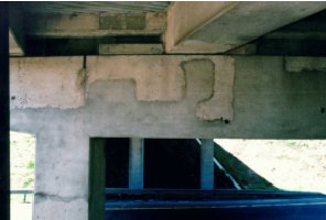 Photo A shows a section of pier 1 and an end column. The patched area, which is lighter in color than the original concrete, begins above the column and extends toward the middle of the pier. In general, the patched area extends approximately halfway down the pier, and the edge moves up and down in a series of right angles. 
