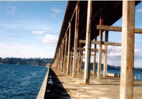 Photo B shows the pillars resting on the pontoon deck and supporting the bridge deck overhead. Each pair of pillars is reinforced horizontally with a crossbeam. 