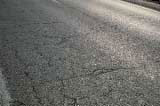 FIGURE 10.  Distress Type ACP 2 - High Severity Block Cracking, Color photograph of asphalt concrete pavement with distress type ACP 2 - high severity block cracking in the wheel path of the lane closest to the center line.  A pattern of more than 15 rectangular blocks is formed by the intersecting cracks.