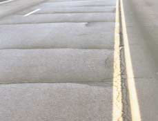 FIGURE 17.   Distress Type ACP 5 - High Severity Reflection Cracking at Joints, Color photograph of asphalt concrete pavement with distress type ACP 5 - high severity reflection cracking at joints. The photo shows five uniformly spaced joint reflection cracks across the entire width of the lane and longitudinal joint cracking along the entire length of the center line.