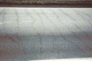FIGURE 97.  Distress Type CRCP 3 - Transverse Cracking Pattern,Color photograph of continuously reinforced concrete pavement with distress type CRCP 3 - transverse cracking pattern. A lane of pavement is depicted that has nine transverse cracks that extend from the center line to the lane edge.  No significant spalling is evident.