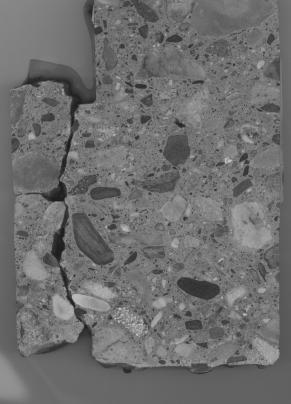 Figure 3-10 (a):  Photographs.  Slab 2B stained with sodium cobatinitrite/rhodamine B from SD-090-019-002.  This figure is comprised of four photographs of slab 2B, labeled A, B, C, and D.  The slab was stained with cobaltinitrite/rhodamine B. Photograph A is a picture of the entire stained slab.  The slab is cracked on the left hand side, but this possibly resulted when the slab was being cut.  Photograph B is of a reactive aggregate particle found in the slab.  Photograph C is a picture of an ASR gel filled void that abuts a larger aggregate particle.  Reaction rims are visible around the aggregate.  Photograph D is of a reactive aggregate particle.