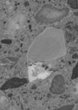  Figure 3-10 (c):  Photographs.  Slab 2B stained with sodium cobatinitrite/rhodamine B from SD-090-019-002.  This figure is comprised of four photographs of slab 2B, labeled A, B, C, and D.  The slab was stained with cobaltinitrite/rhodamine B. Photograph A is a picture of the entire stained slab.  The slab is cracked on the left hand side, but this possibly resulted when the slab was being cut.  Photograph B is of a reactive aggregate particle found in the slab.  Photograph C is a picture of an ASR gel filled void that abuts a larger aggregate particle.  Reaction rims are visible around the aggregate.  Photograph D is of a reactive aggregate particle.