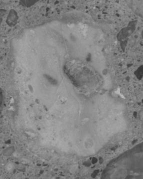  Figure 3-10 (d):  Photographs.  Slab 2B stained with sodium cobatinitrite/rhodamine B from SD-090-019-002.  This figure is comprised of four photographs of slab 2B, labeled A, B, C, and D.  The slab was stained with cobaltinitrite/rhodamine B. Photograph A is a picture of the entire stained slab.  The slab is cracked on the left hand side, but this possibly resulted when the slab was being cut.  Photograph B is of a reactive aggregate particle found in the slab.  Photograph C is a picture of an ASR gel filled void that abuts a larger aggregate particle.  Reaction rims are visible around the aggregate.  Photograph D is of a reactive aggregate particle.