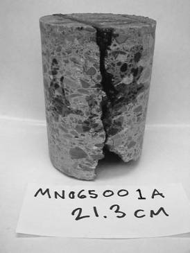  Figure 3-22  (d):  Photographs.  Cores evaluated for MN-065-064.  This figure is comprised of four photographs of cores, labeled A through D.  Photograph A is a picture of core MN065001A.  The core was taken from the road surface down to a depth of 20.3 centimeters and was at the transverse joint.  There is some evidence of deterioration at the bottom of the core.  Photograph B is a picture of core MN065001B.  The core was taken from the road surface down to a depth of 18 centimeters and also was taken at the transverse joint.  It too shows evidence of deterioration.  Photograph C is a picture of core MN065001D.  The core was taken from the road surface down to a depth of 20 centimeters, away from any joints.  It does not show any evidence of distress.  Photograph D is a picture of core MN065001* and is a core taken from the left turn lane, away from any joints.  The core was taken from the road surface down to a depth of 21 centimeters.  No evidence of distress is visible.